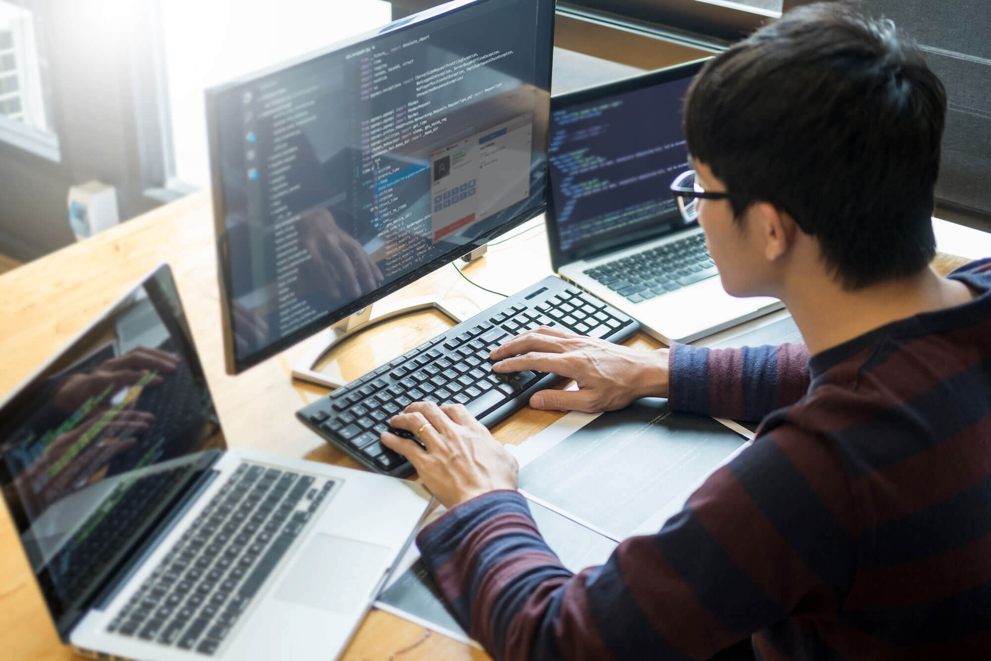 Man working on computer laptops